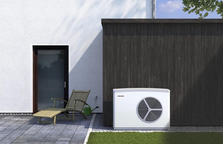 Zunanja enota toplotne črpalke zrak-voda ob ograji