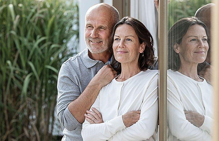 Romantični par zadovoljno gleda skozi okno.